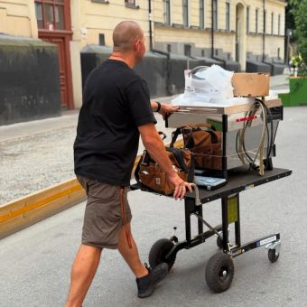 Barista using Demtruk Folding Cart to move a commercial coffee machine safely