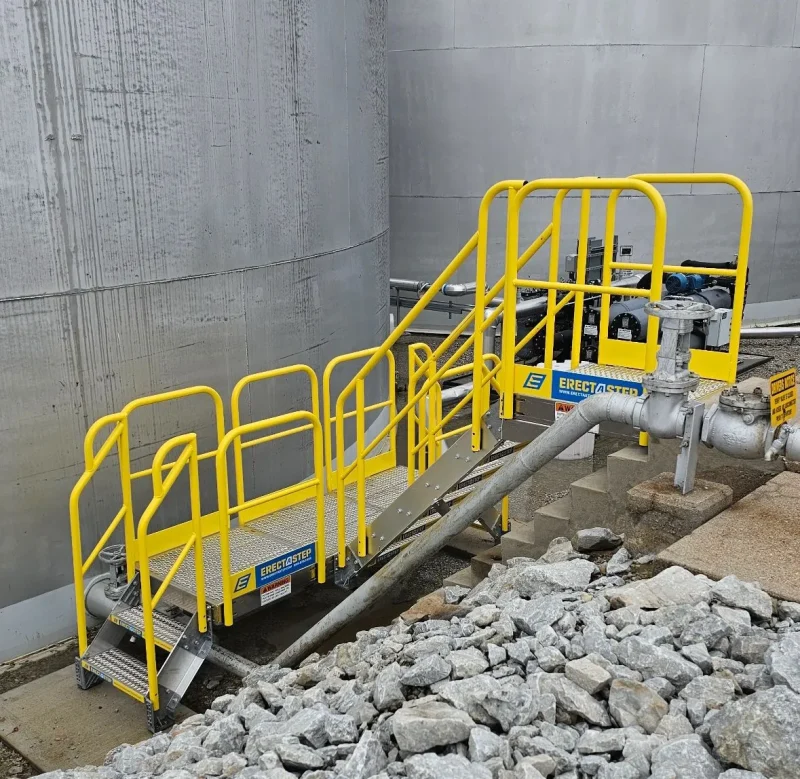 Workers accessing a fuel containment berm via the ErectaStep Stair System installed for rapid, compliant entry in a remote substation.